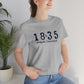 1835 Small Minuteman Unisex Jersey Short Sleeve Tee